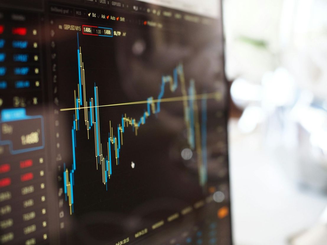 Financial stock chart on computer screen, blue and yellow lines.