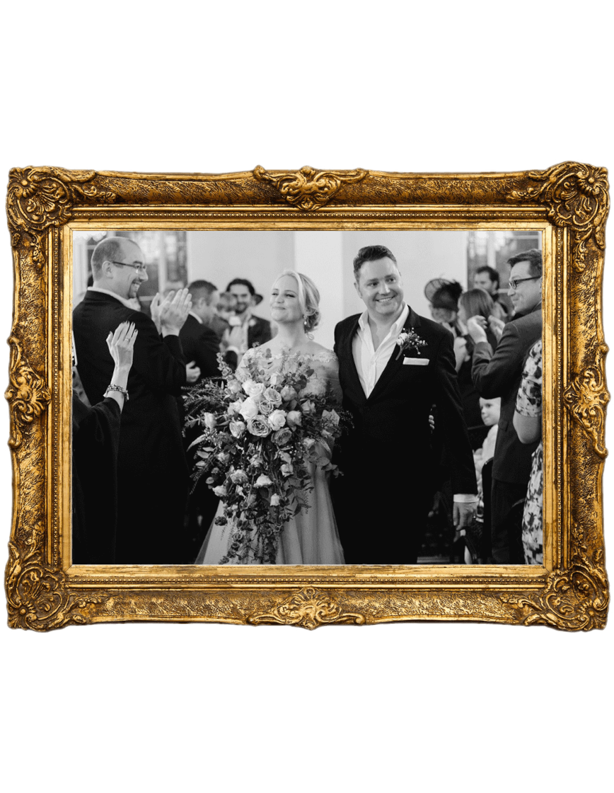 a black and white photo of a bride and groom in a gold frame .