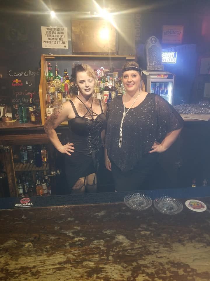 Two women are posing for a picture in a bar.