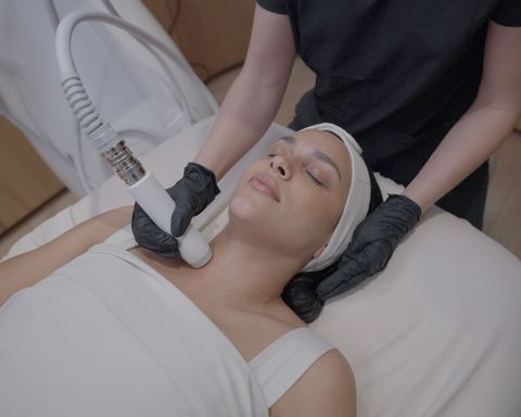Woman receiving neck skin treatment from a gloved aesthetician. Woman receiving neck skin treatment from a gloved aesthetician.