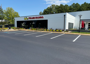 Road closed for repairs, orange and white striped cones and barrier blocking a pothole.