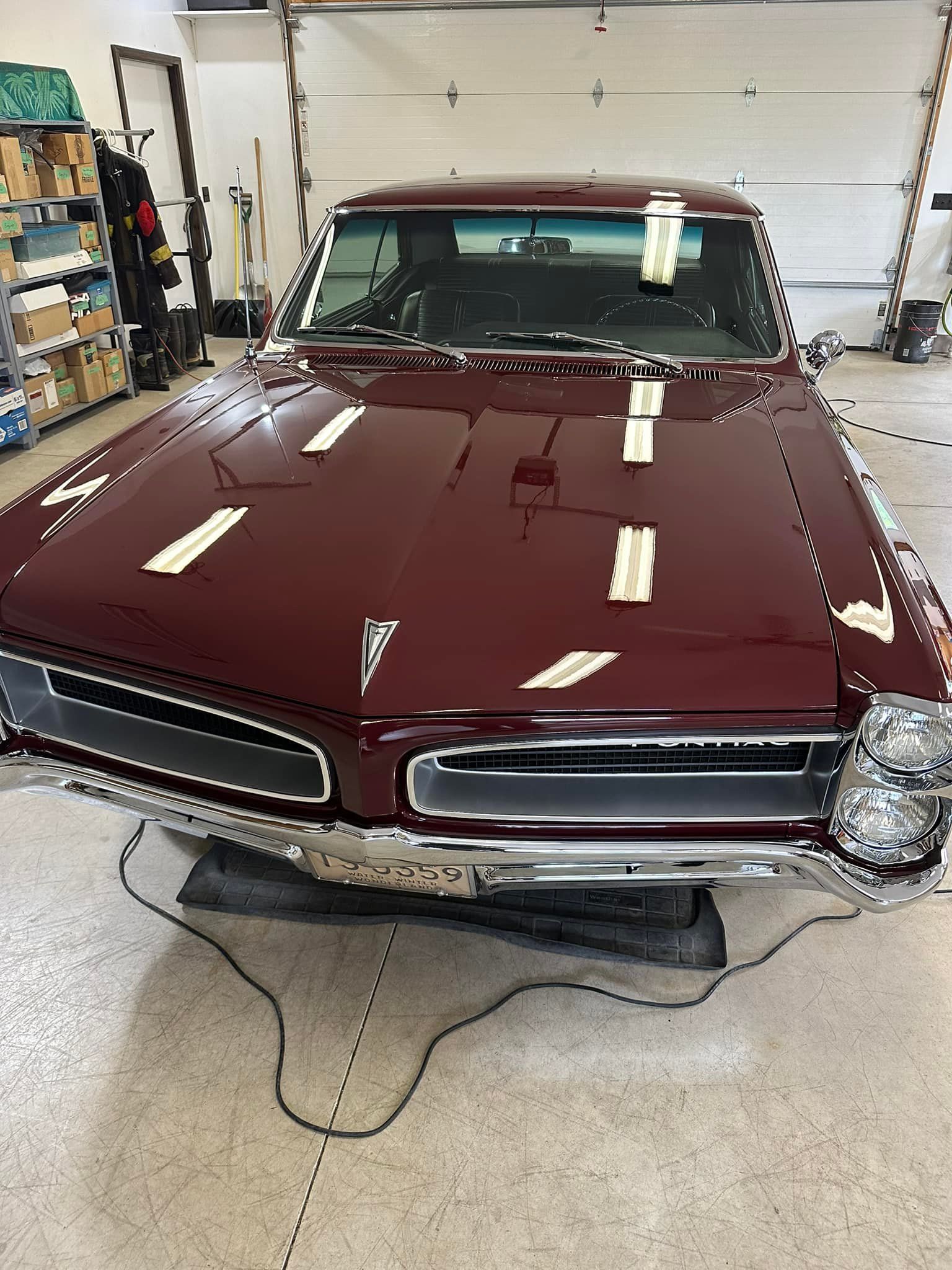 Burgundy classic Pontiac car in a garage with a glossy finish.