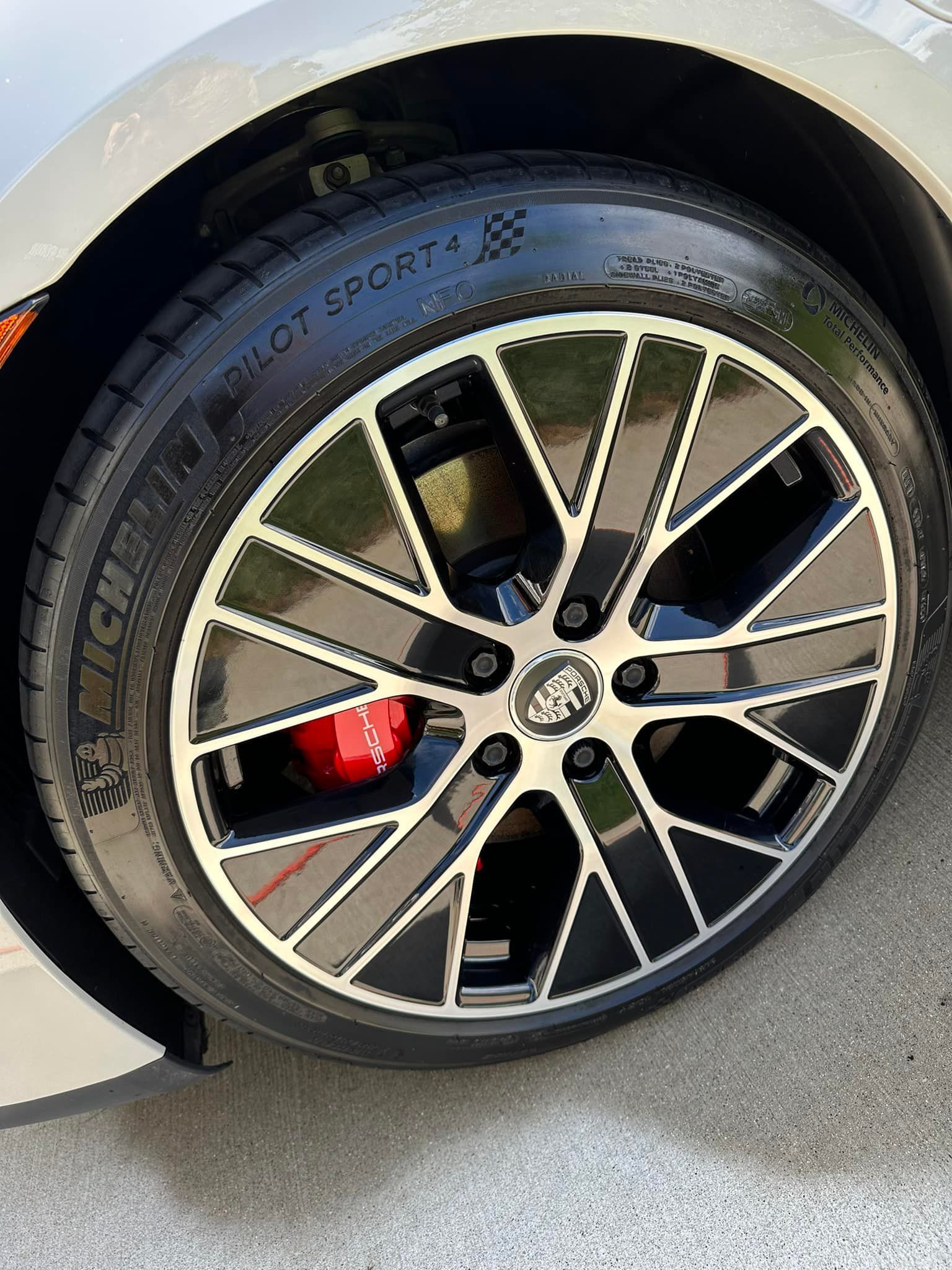 Car wheel with a black and silver rim, Michelin Pilot Sport tire, and red brake caliper.