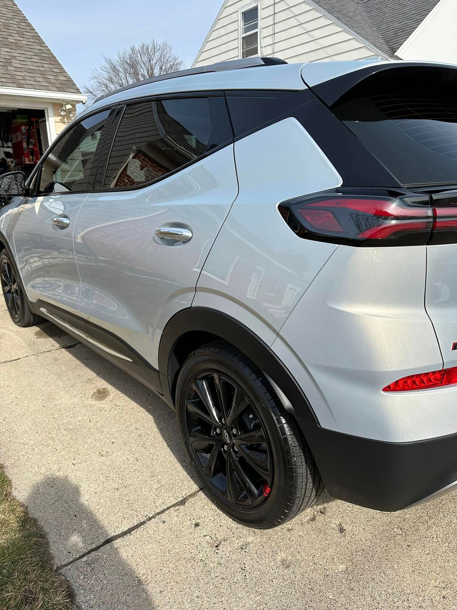 Silver SUV parked on a paved driveway with black rims; house in the background.