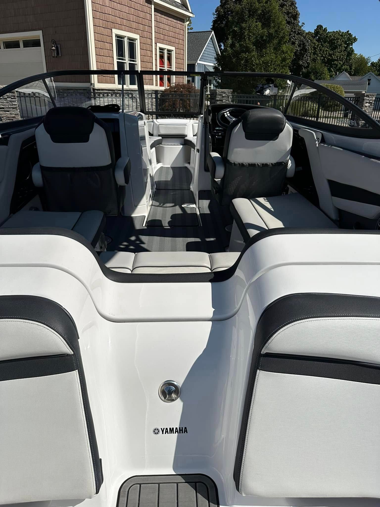 White and gray boat interior with two captain's chairs and stern seating.
