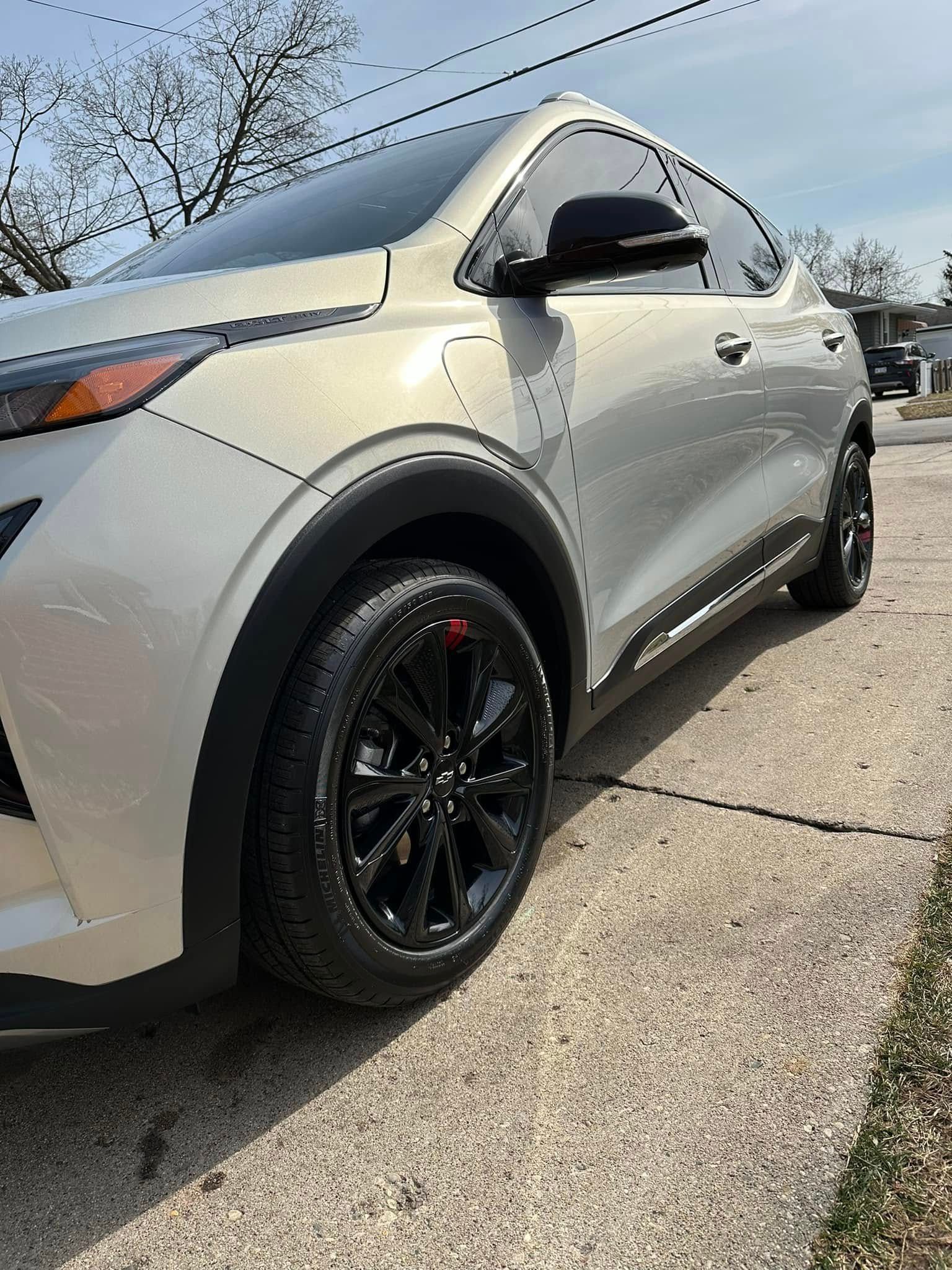 Silver SUV with black rims parked on concrete.