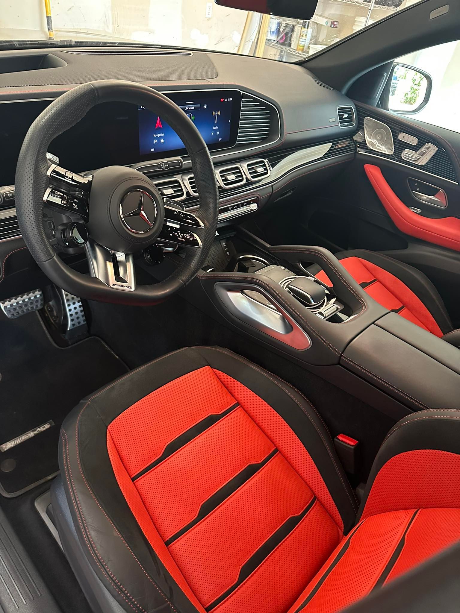 Red and black Mercedes-Benz interior; steering wheel, dashboard, seats, and console visible.