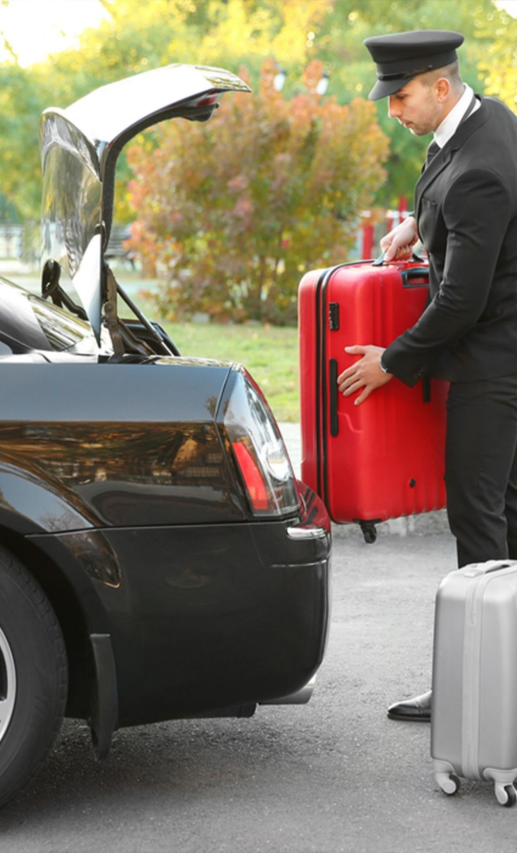 Chauffeur Putting Suitcase in Car Trunk — Transport in Newcastle