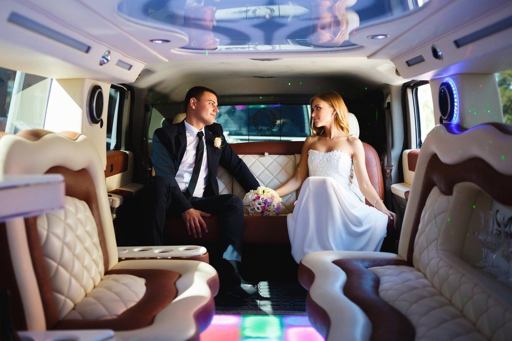 Happy Bride and Groom Sitting in Limousine — Transport in Lake Macquarie, NSW