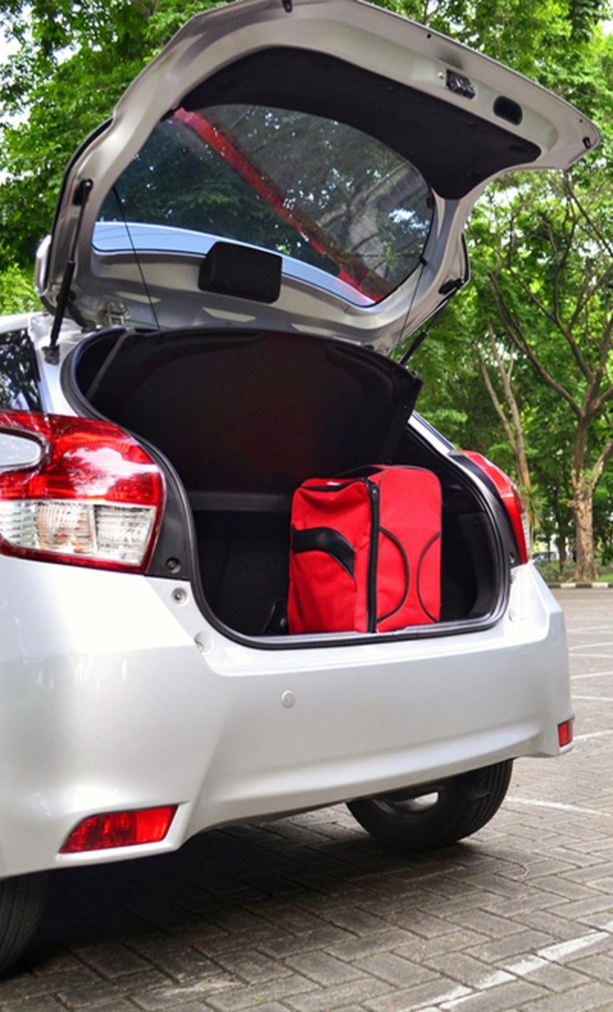 Medium Size Red Luggage in a Hatchback Car Trunk — Transport in Argenton, NSW