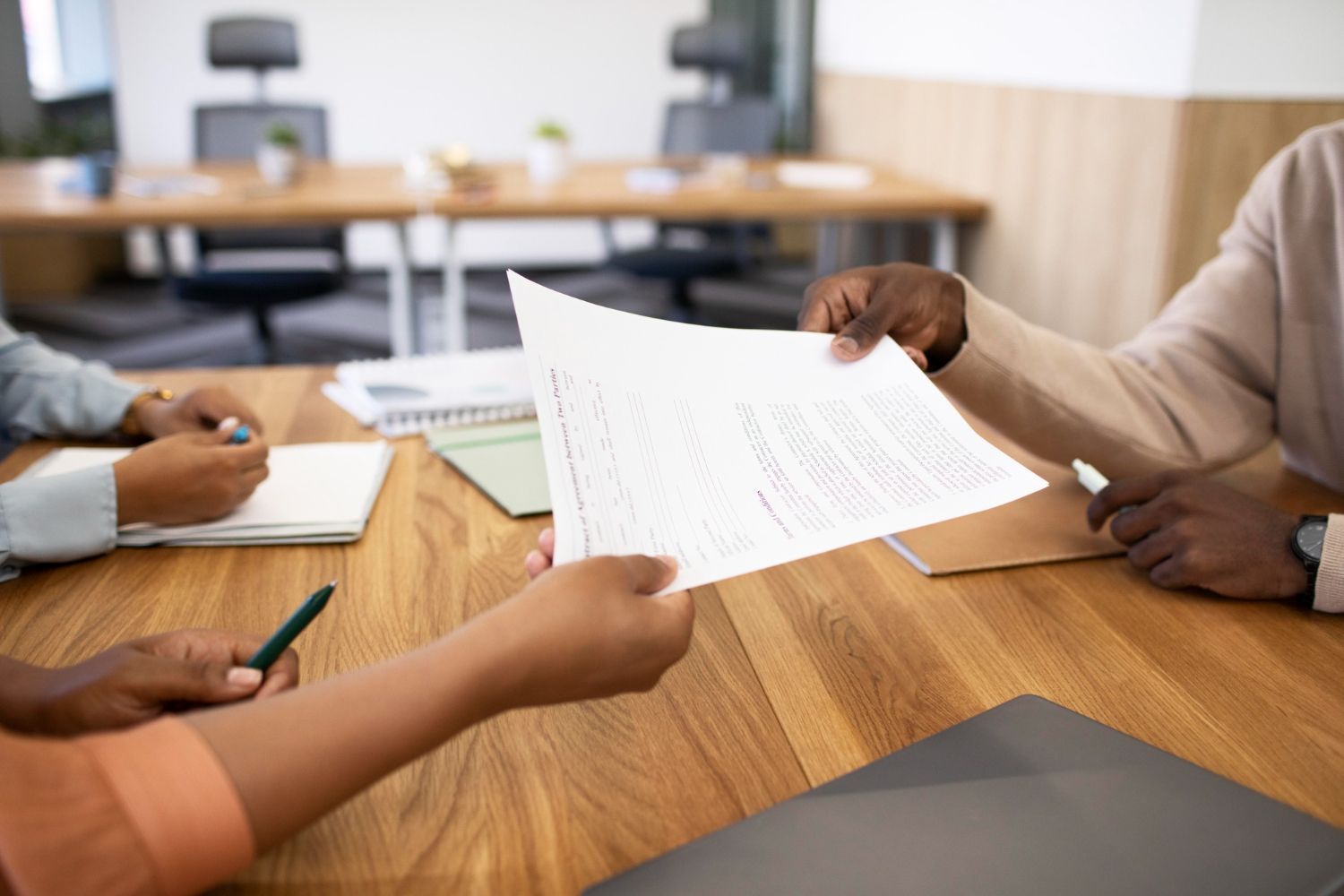A group of people are sitting at a table looking at a piece of paper.