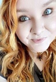 A close up of a woman 's face with red hair and green eyes.