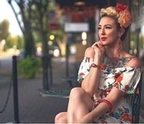 A woman in a floral dress is sitting on a bench.