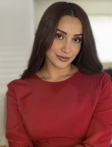 A woman in a red dress is posing for a picture.