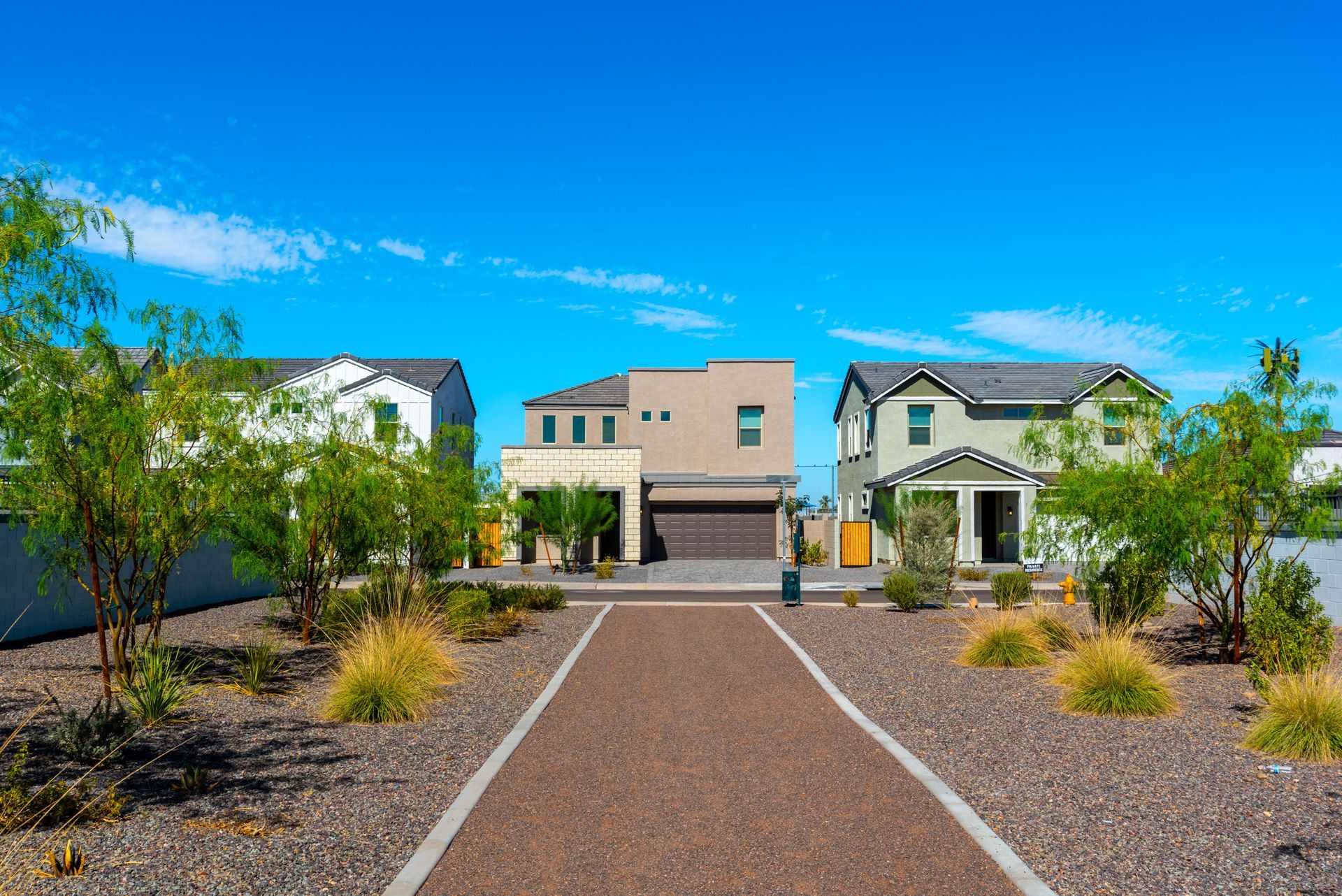 Desert-style homes in Tempe, AZ with decomposed granite landscaping, highlighting areas where seasonal weed control services are needed.