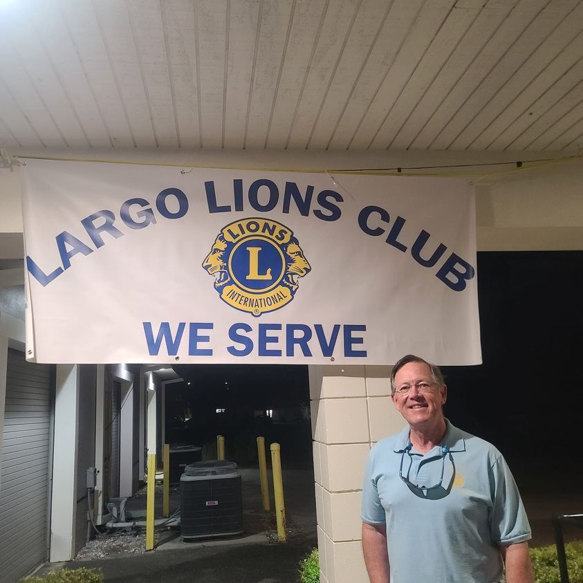 A man stands in front of a largo lions club sign