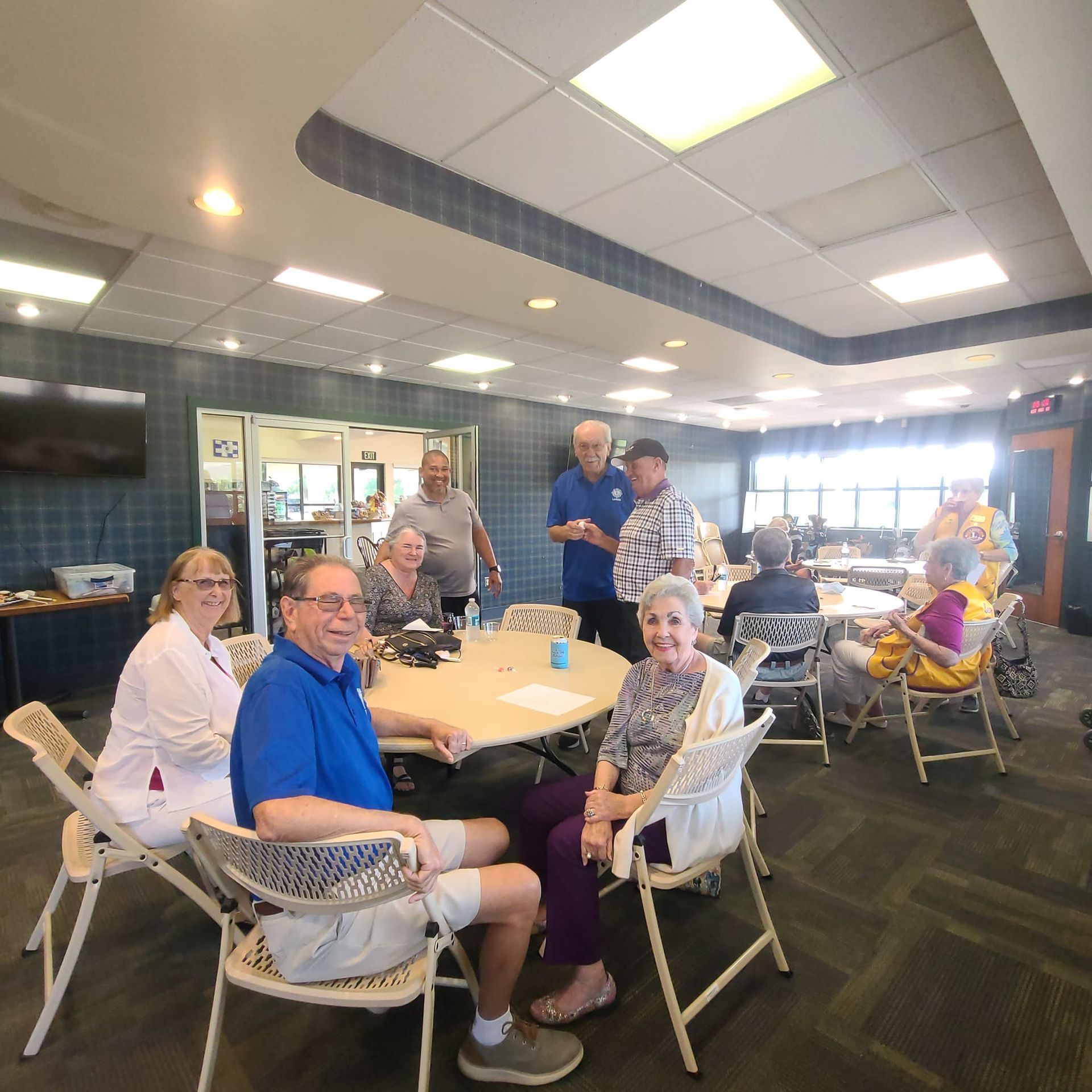 A group of people are sitting around tables in a room