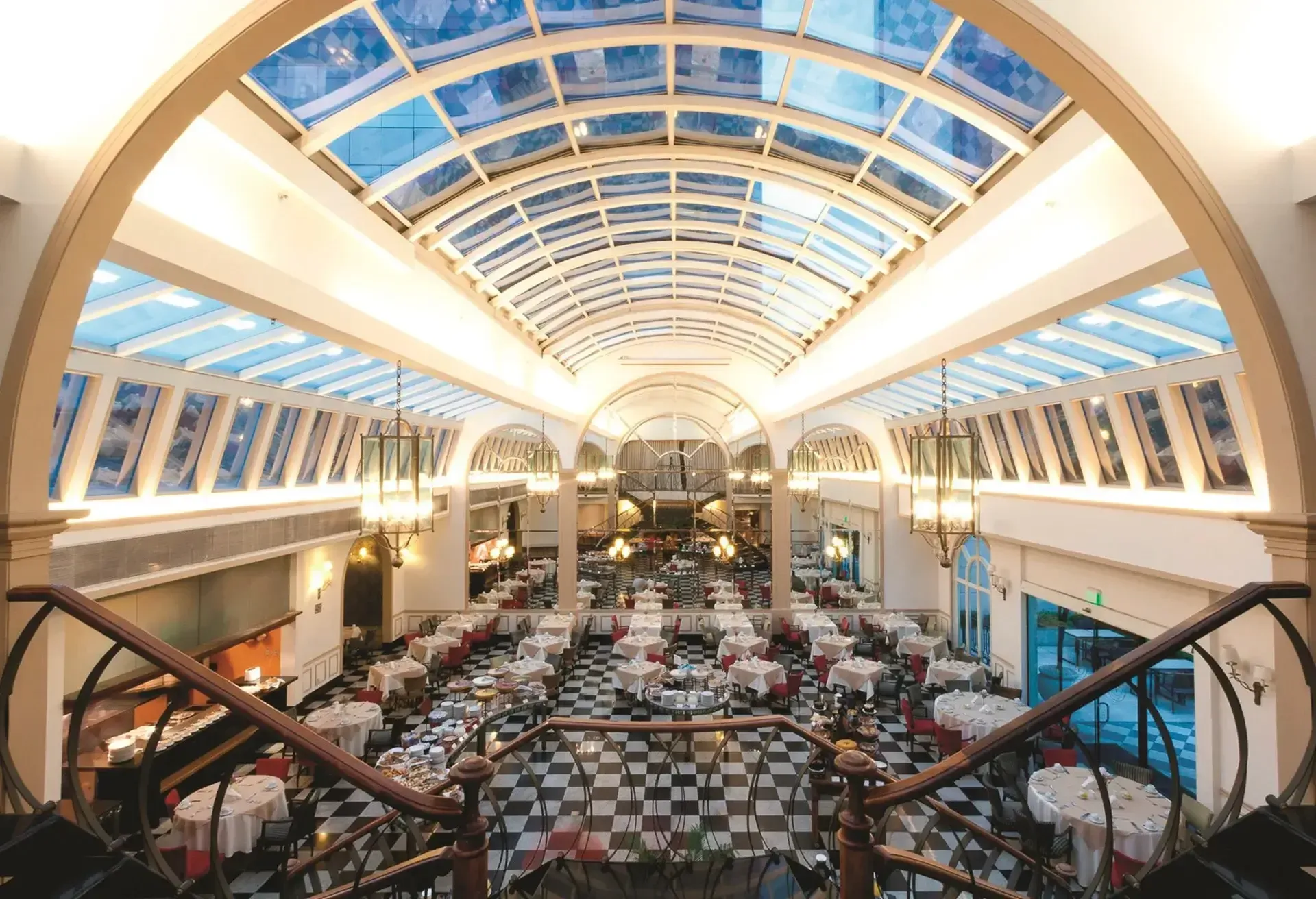 uma grande sala com mesas e cadeiras e teto de vidro