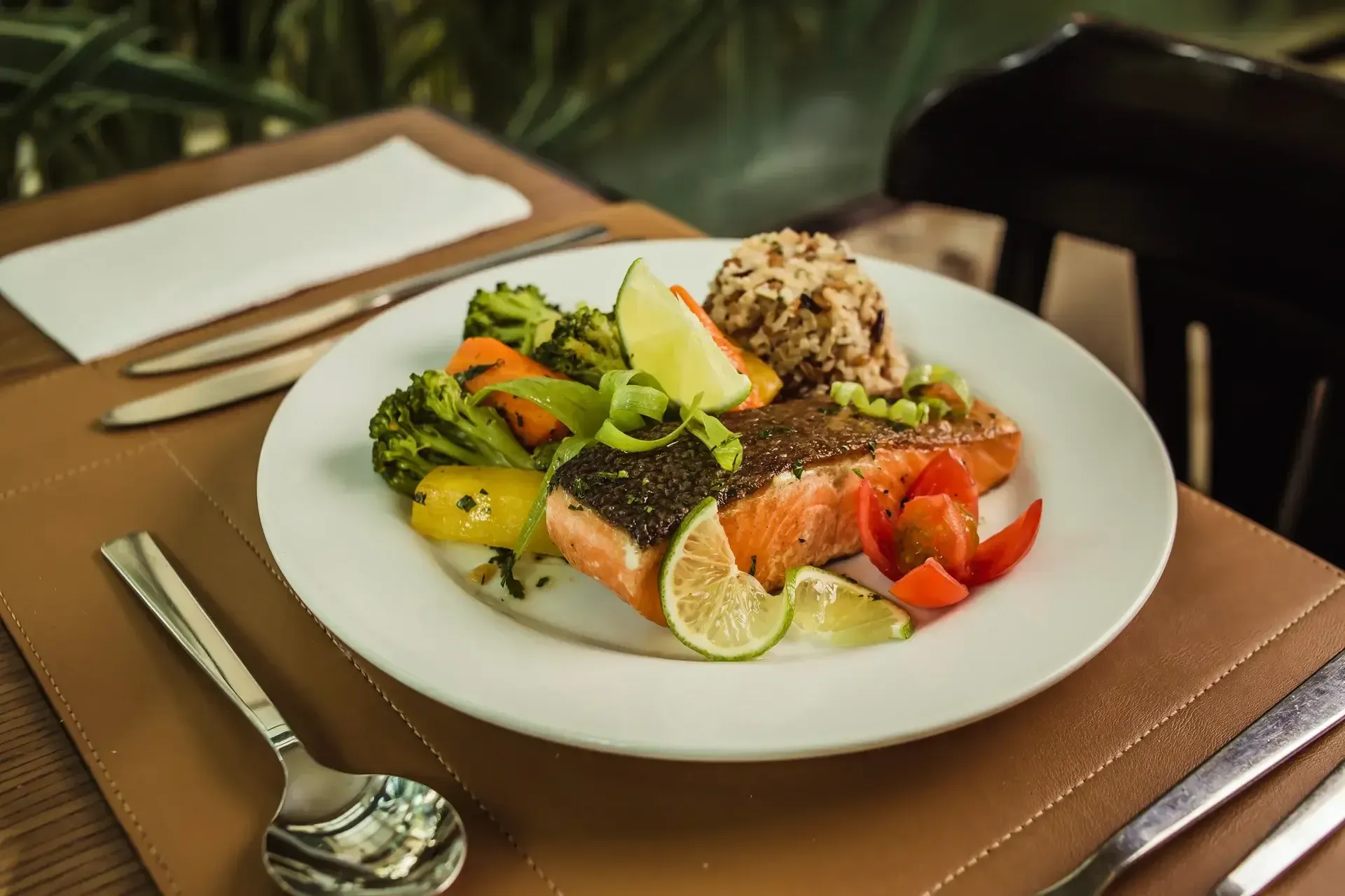 um prato de comida com salmão e legumes sobre uma mesa.