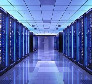 Data center hallway with rows of server racks, illuminated in blue.