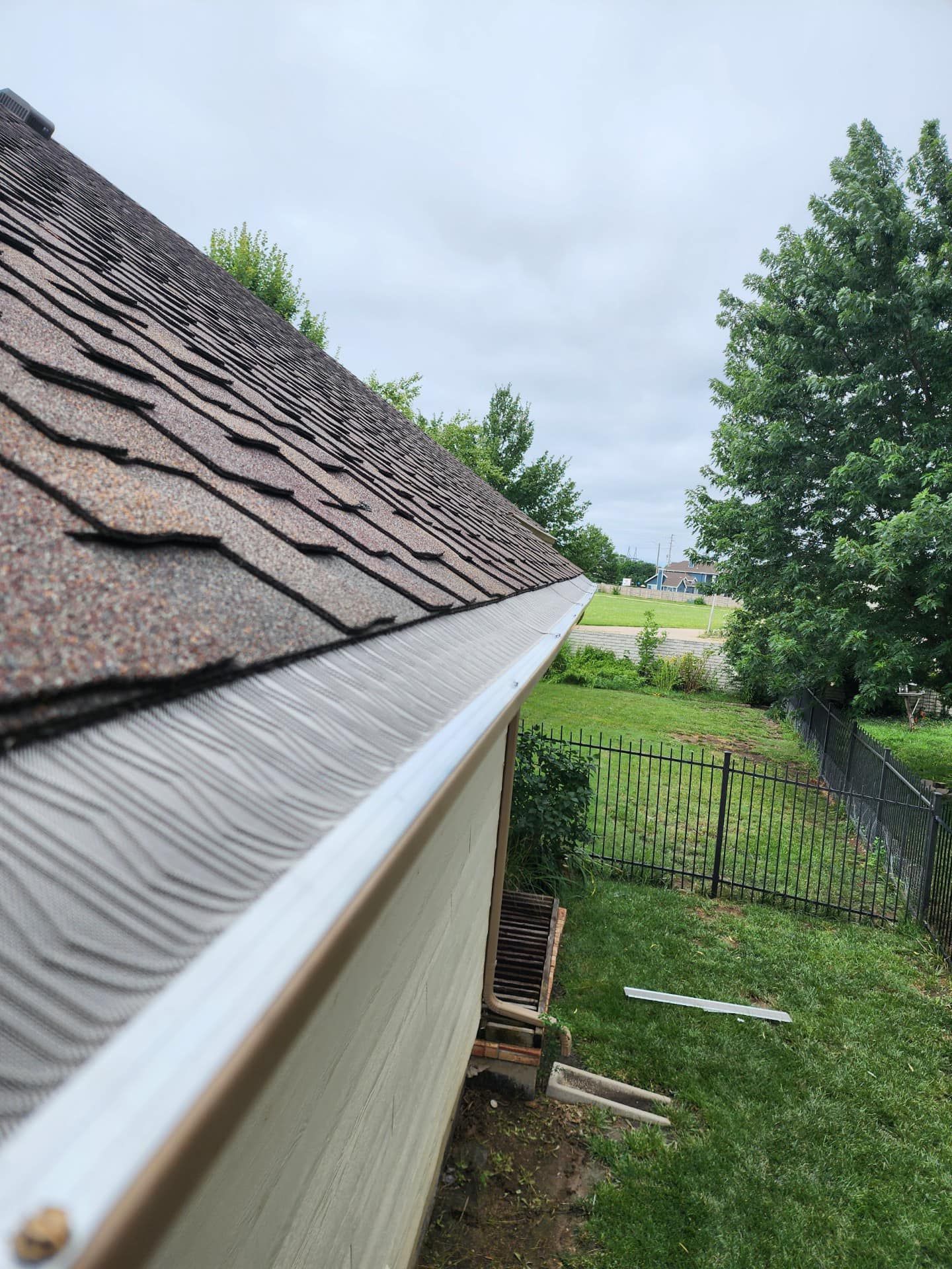 A house with a gutter on the side of it and a roof.