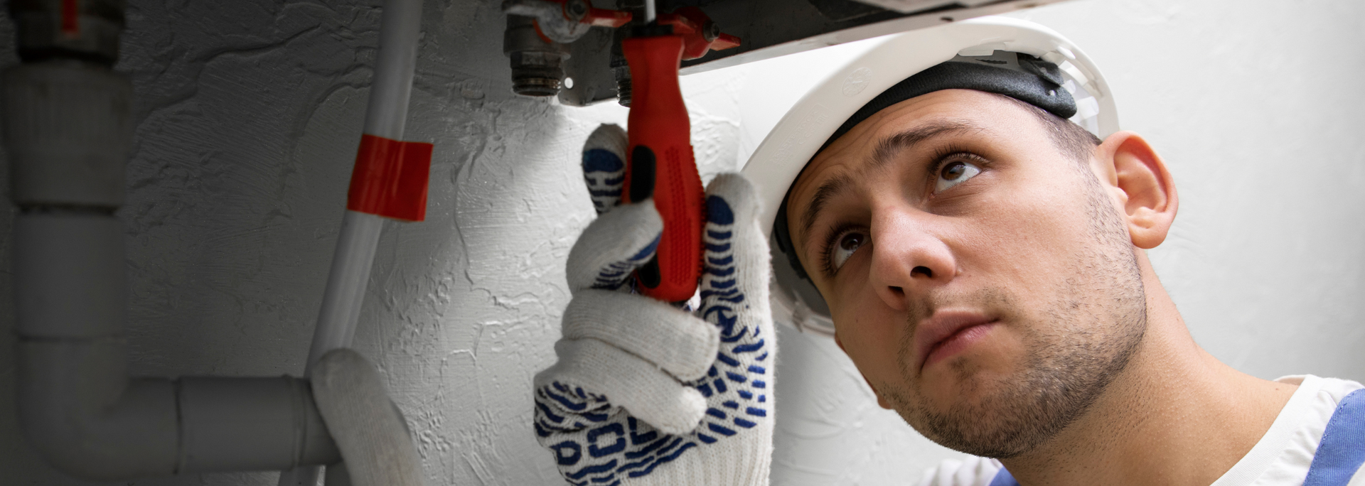 Picture of a plumber working on central heating pipes. Picture of a plumber working on central heating pipes.