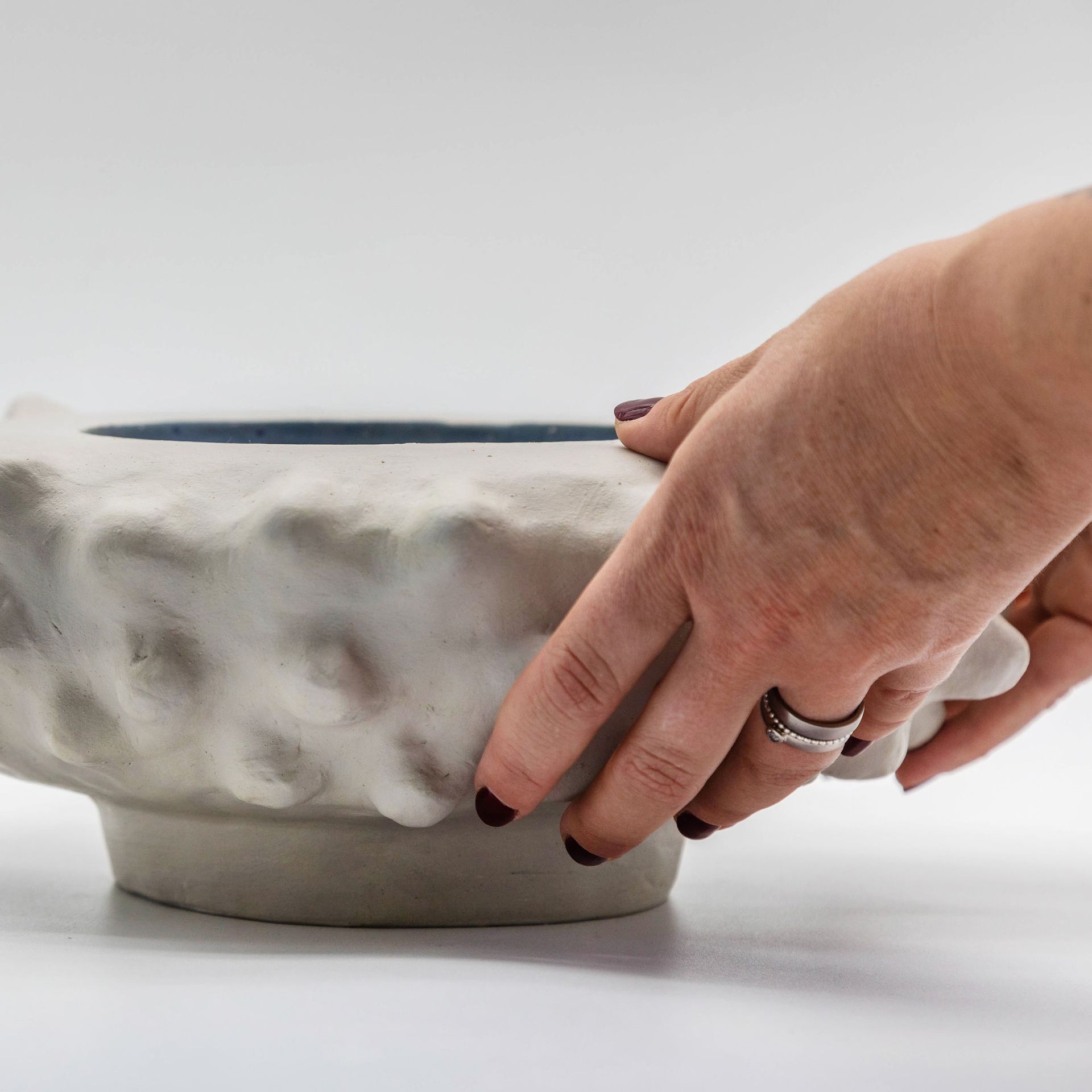 händer på en skål i naturfärg