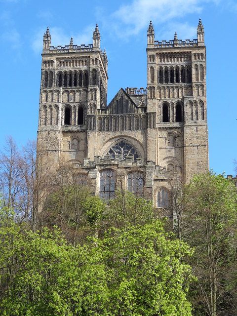 Romansk katedral med massiva torn och rundbågar, symboliserande medeltida andlig auktoritet.