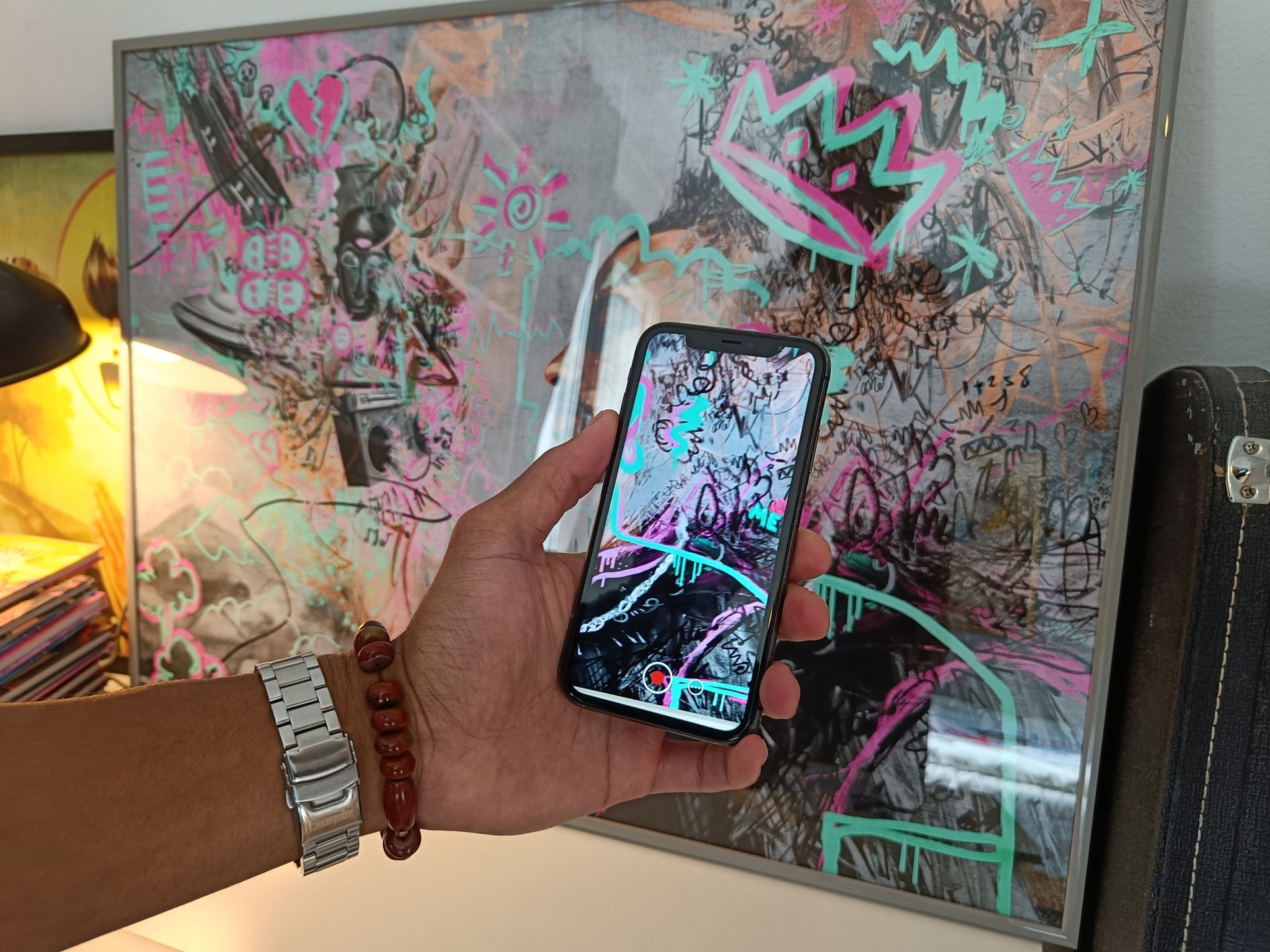 Henric Aryee demonstrerar hur ett självporträtt av honom får liv med hjälp av AR-teknik och en mobiltelefon