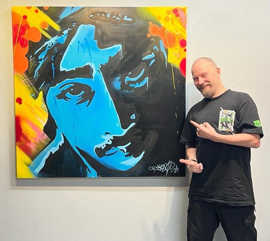 Jonas Finnze visar stolt upp en av sina målningar