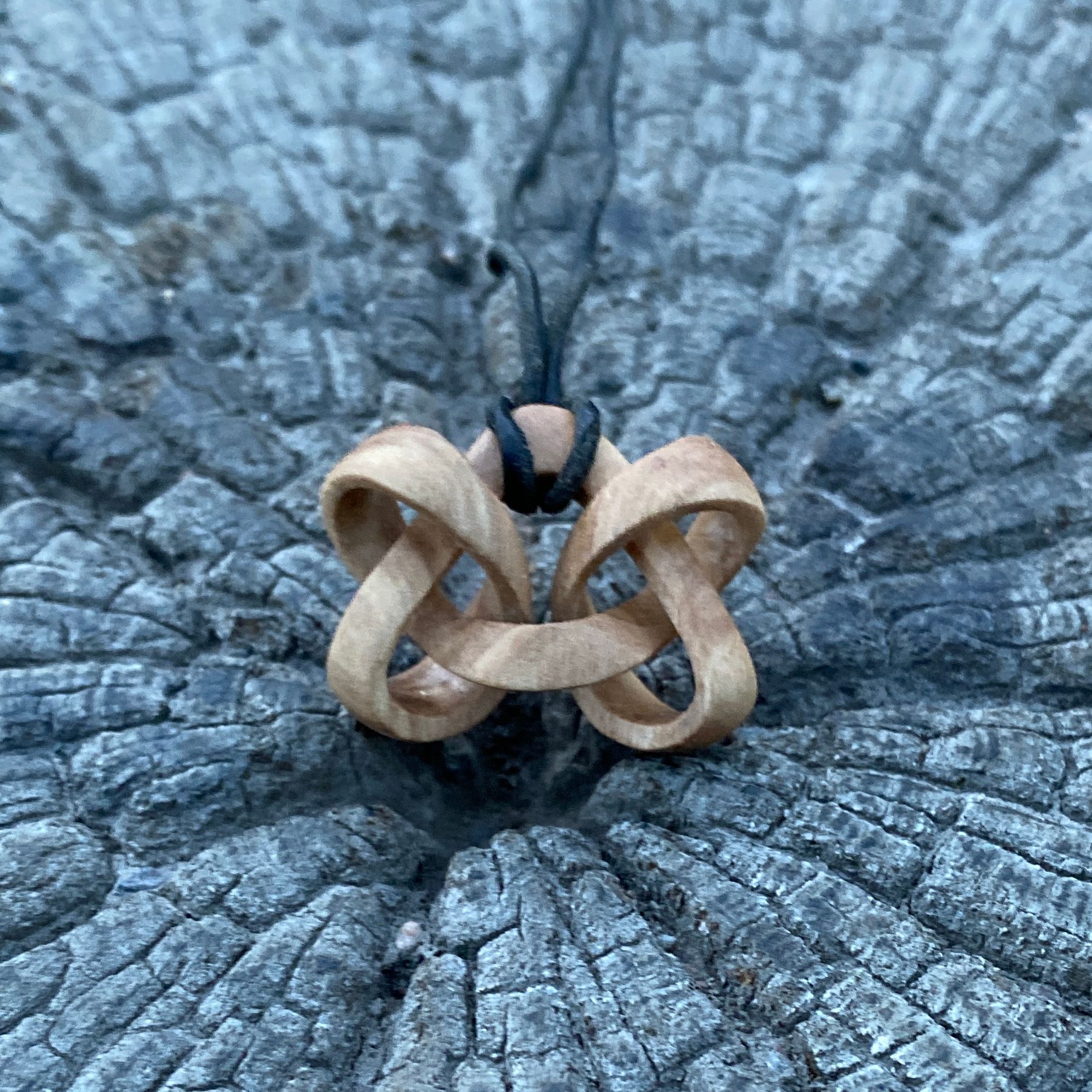 'Ditrefoil' - halssmycke i form av en komplex knut tillverkat av Jörgen Wisén, av ett helt stycke trä