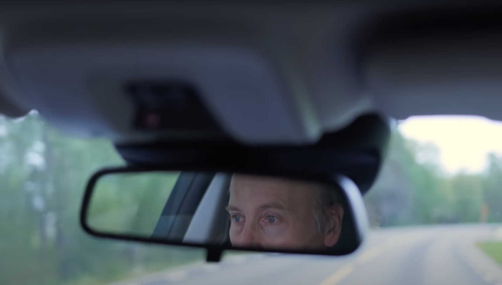 en mans ögon syns i en backspegel