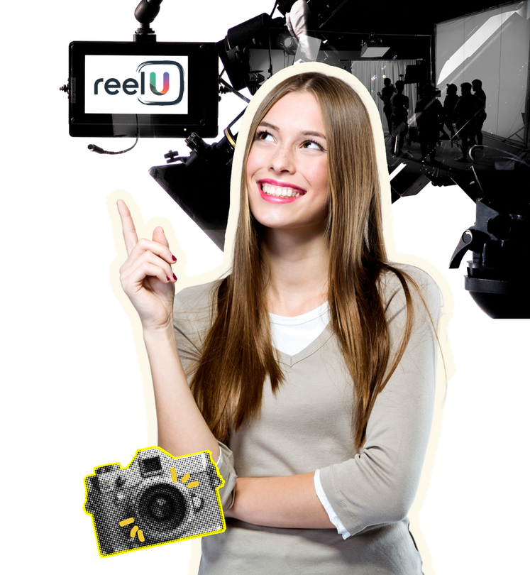 A woman is holding a camera in front of a sign that says reelu