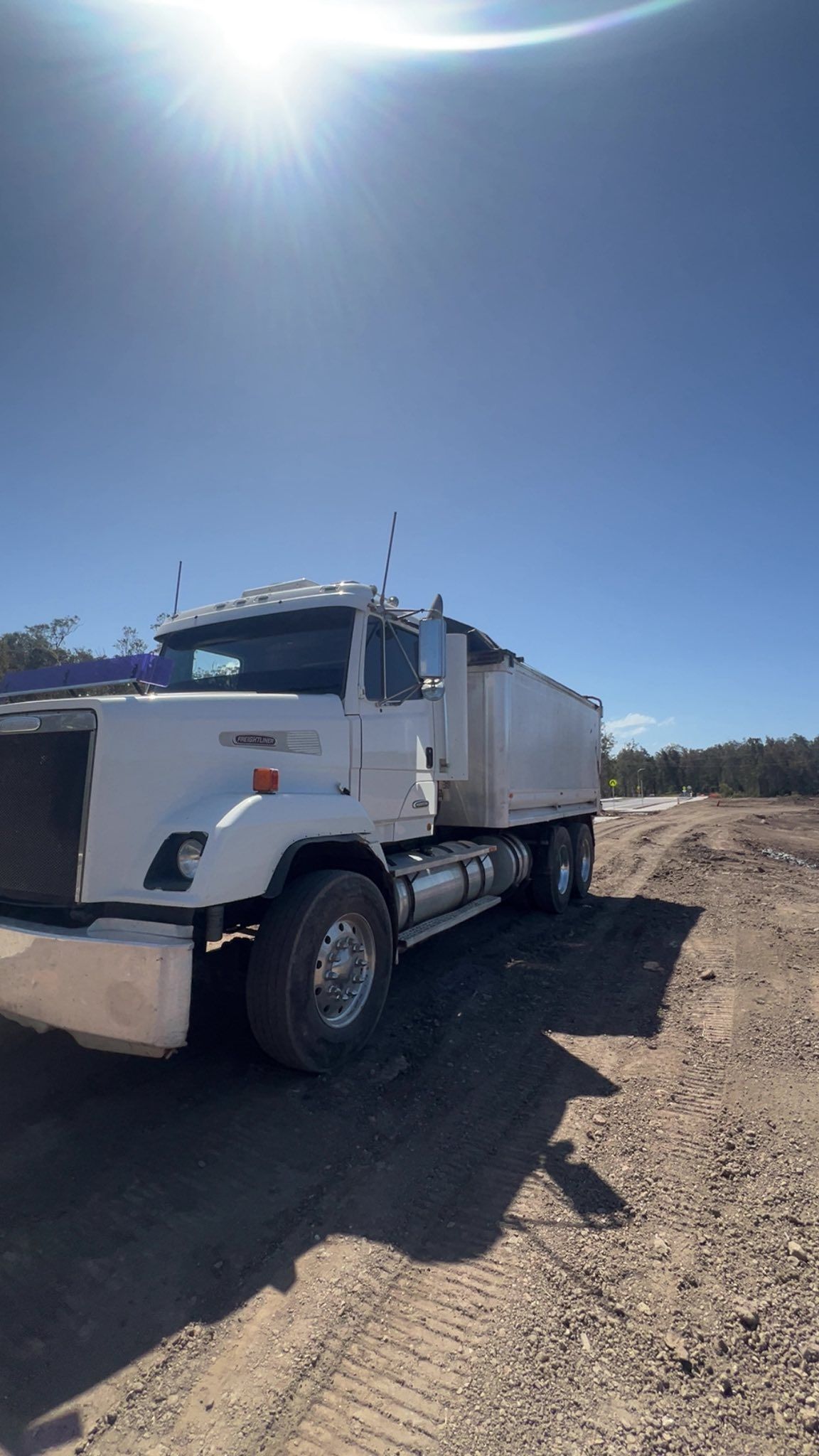 White Dump Truck Parked on a Dirt Road Under a Sunny Blue Sky — North Coast Heavy Diesel In Thrumster, NSW