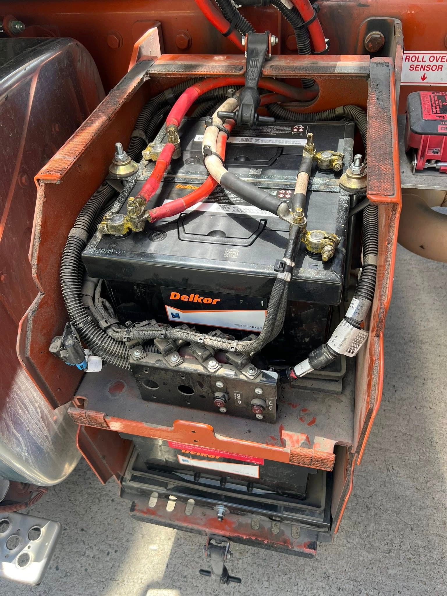 Orange Truck Battery Compartment Holding a Black Battery — North Coast Heavy Diesel In Coffs Harbour, NSW