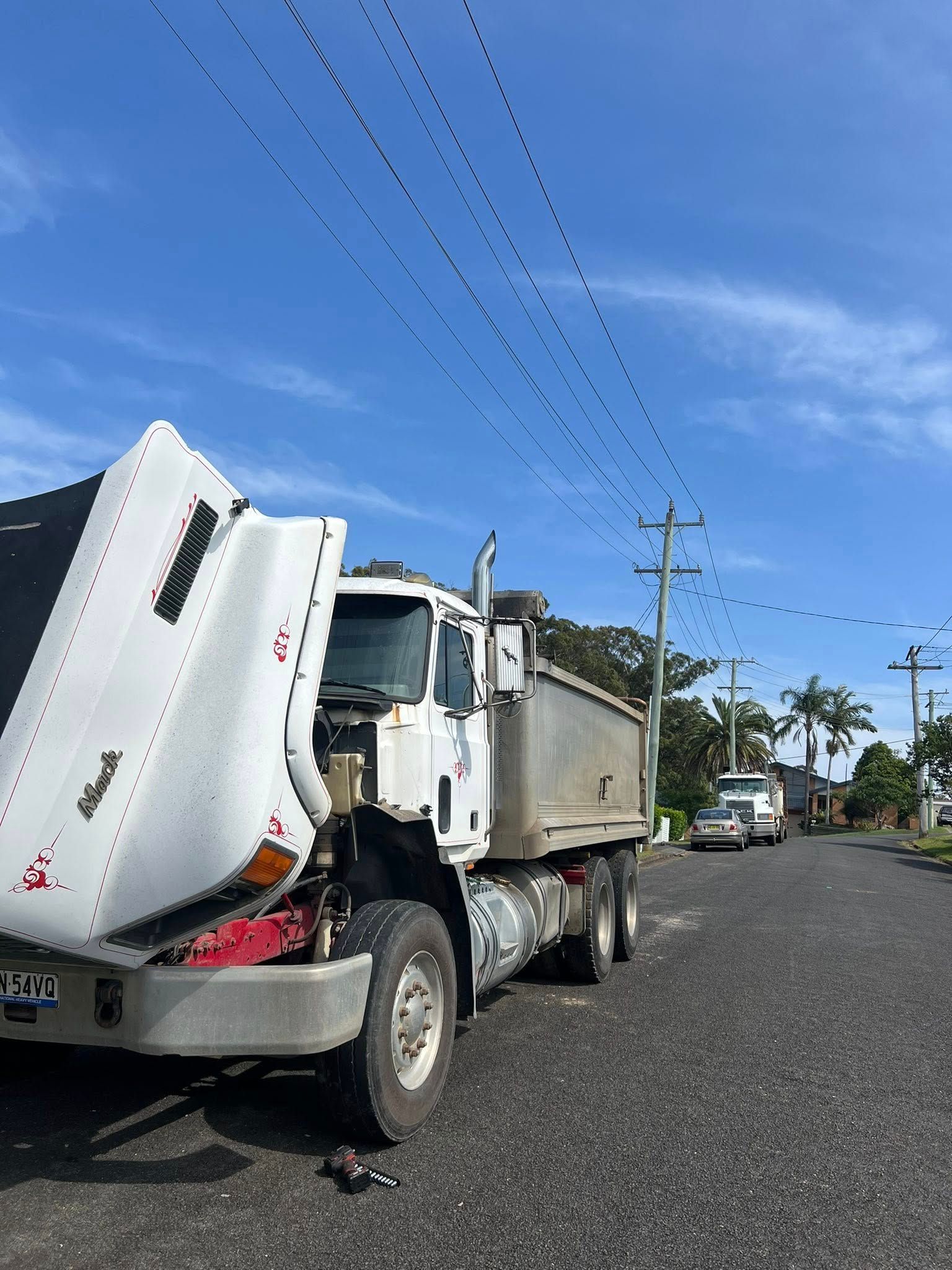 Dump Truck With Hood Up on a Street With Power Lines — North Coast Heavy Diesel In Kempsey, NSW