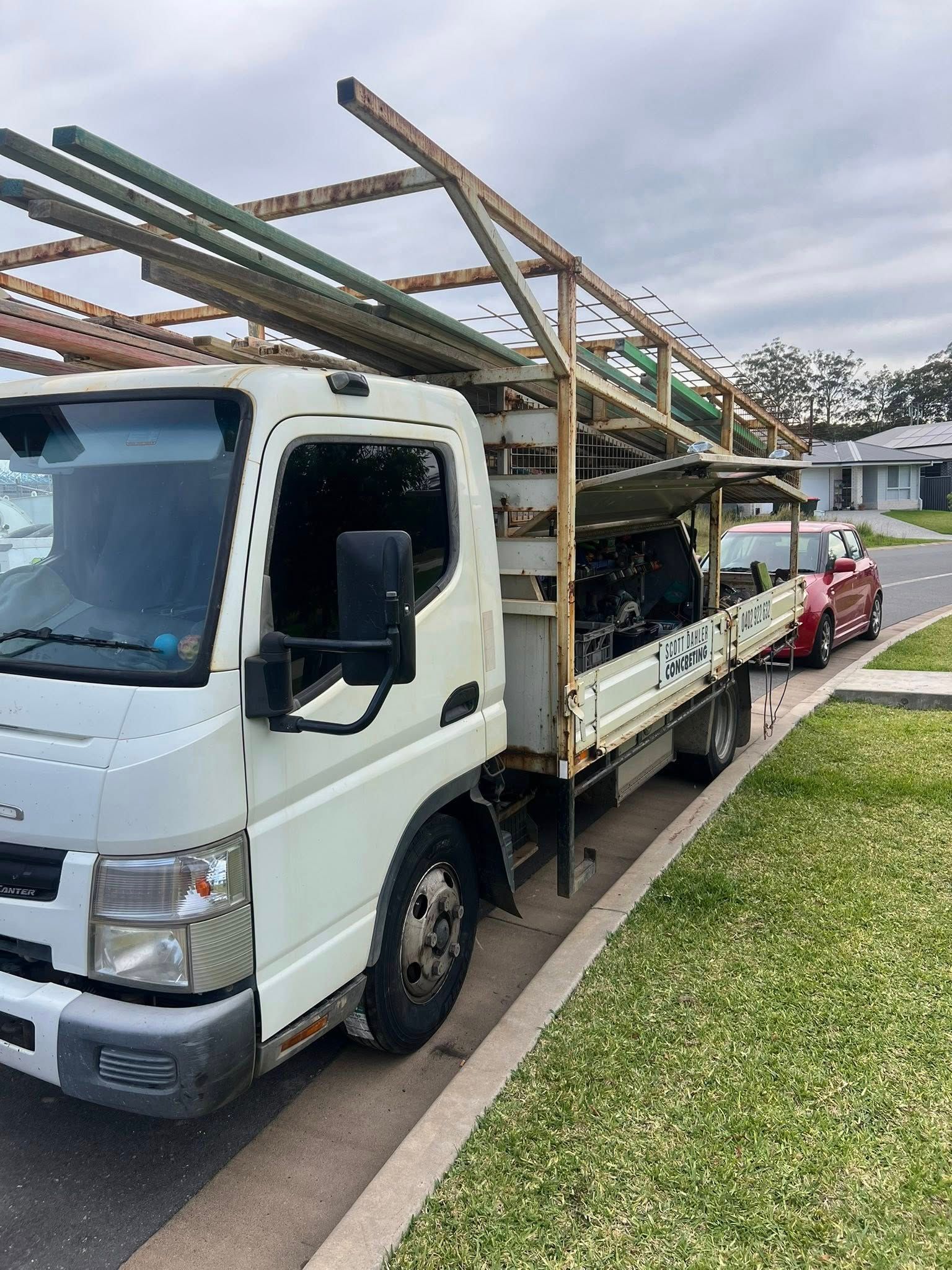 White Truck With Metal Frame Carrying Pipes Parked — North Coast Heavy Diesel In Coffs Harbour, NSW