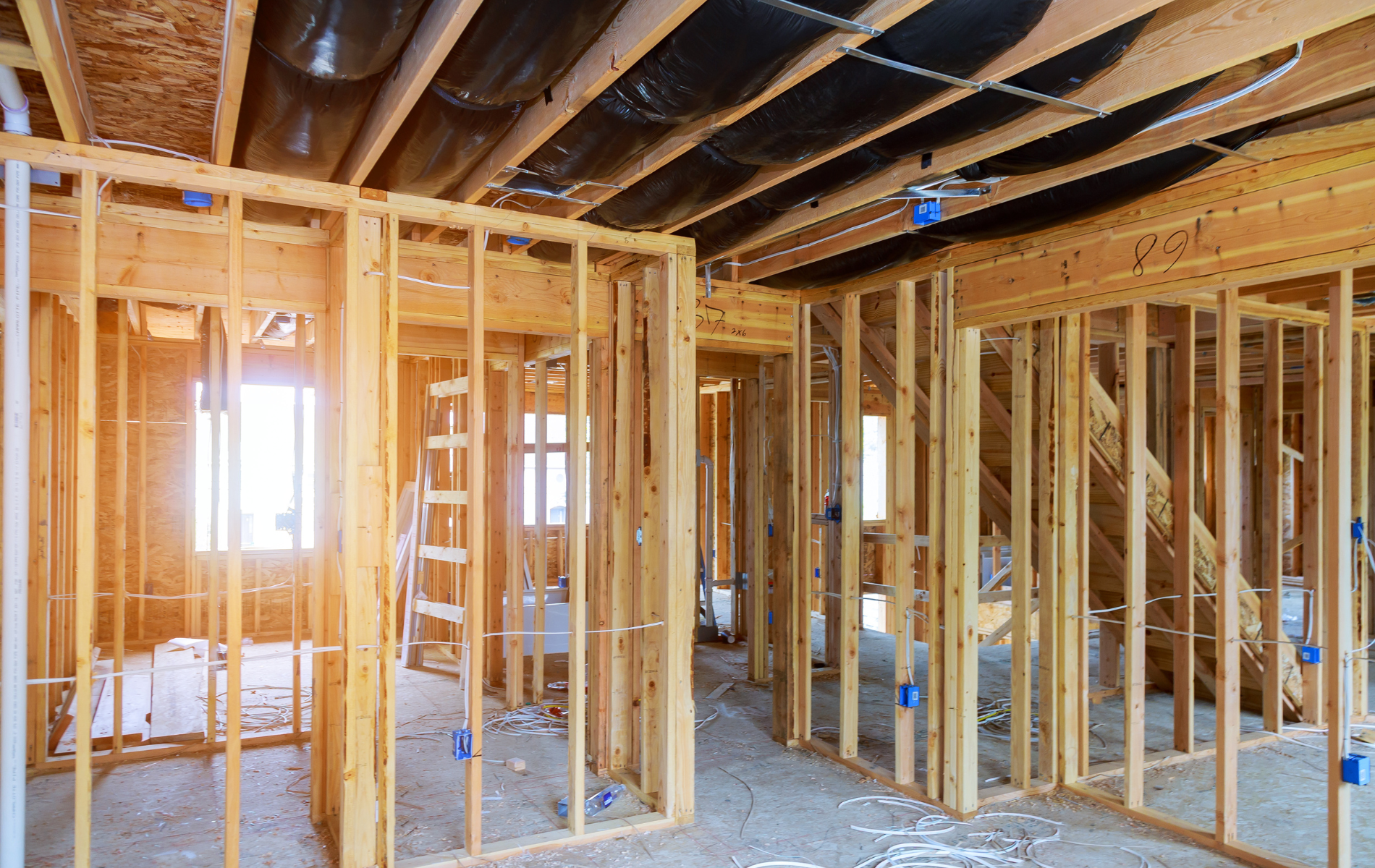 A house is being built with wooden beams and a ladder.