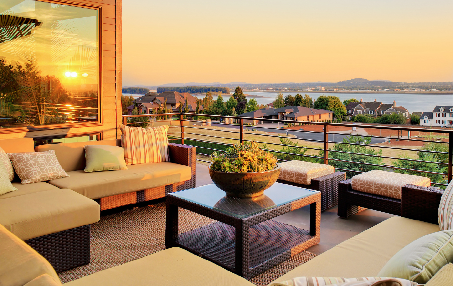A balcony with a view of the ocean and a sunset.