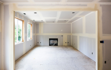 An empty room with a fireplace and a lot of windows