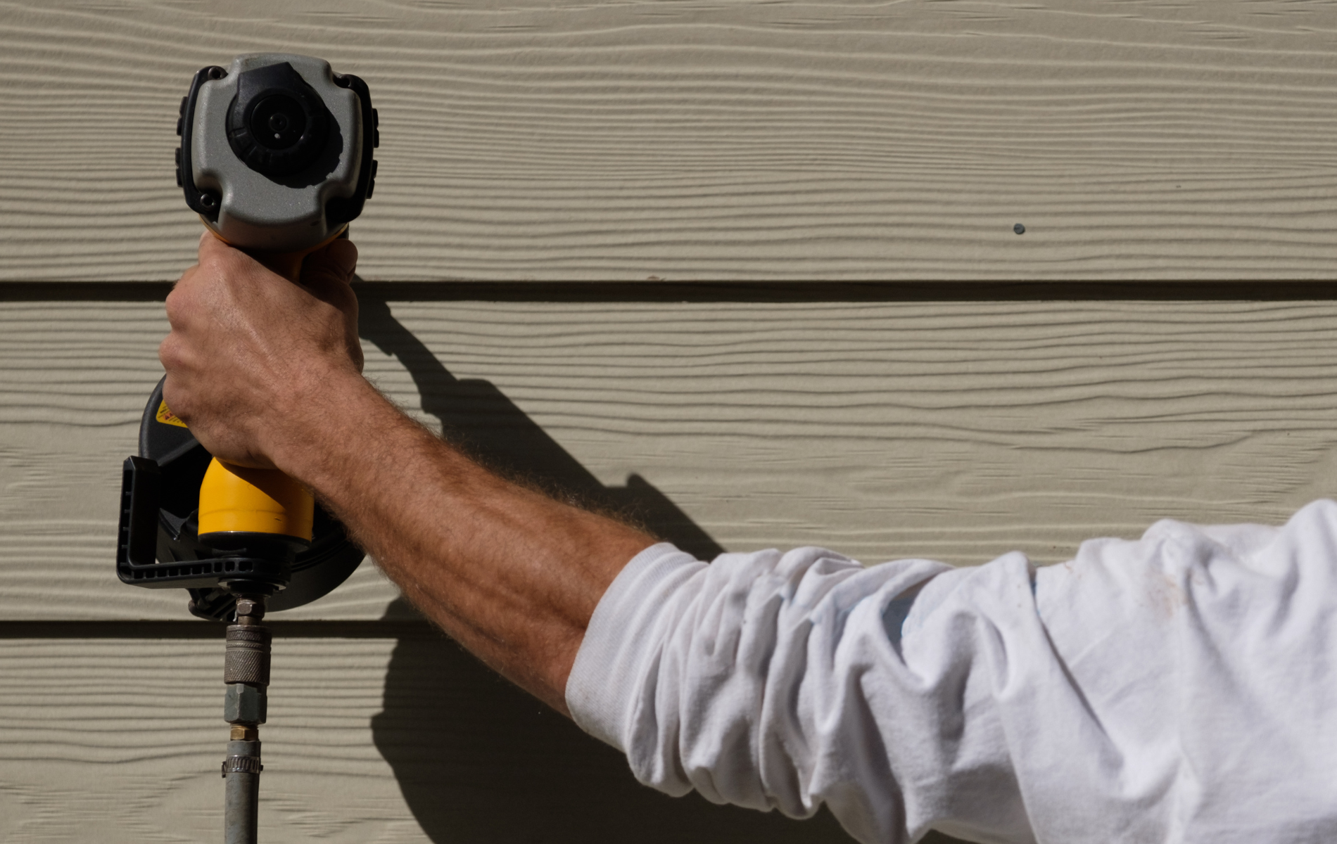 A man drilling a siding