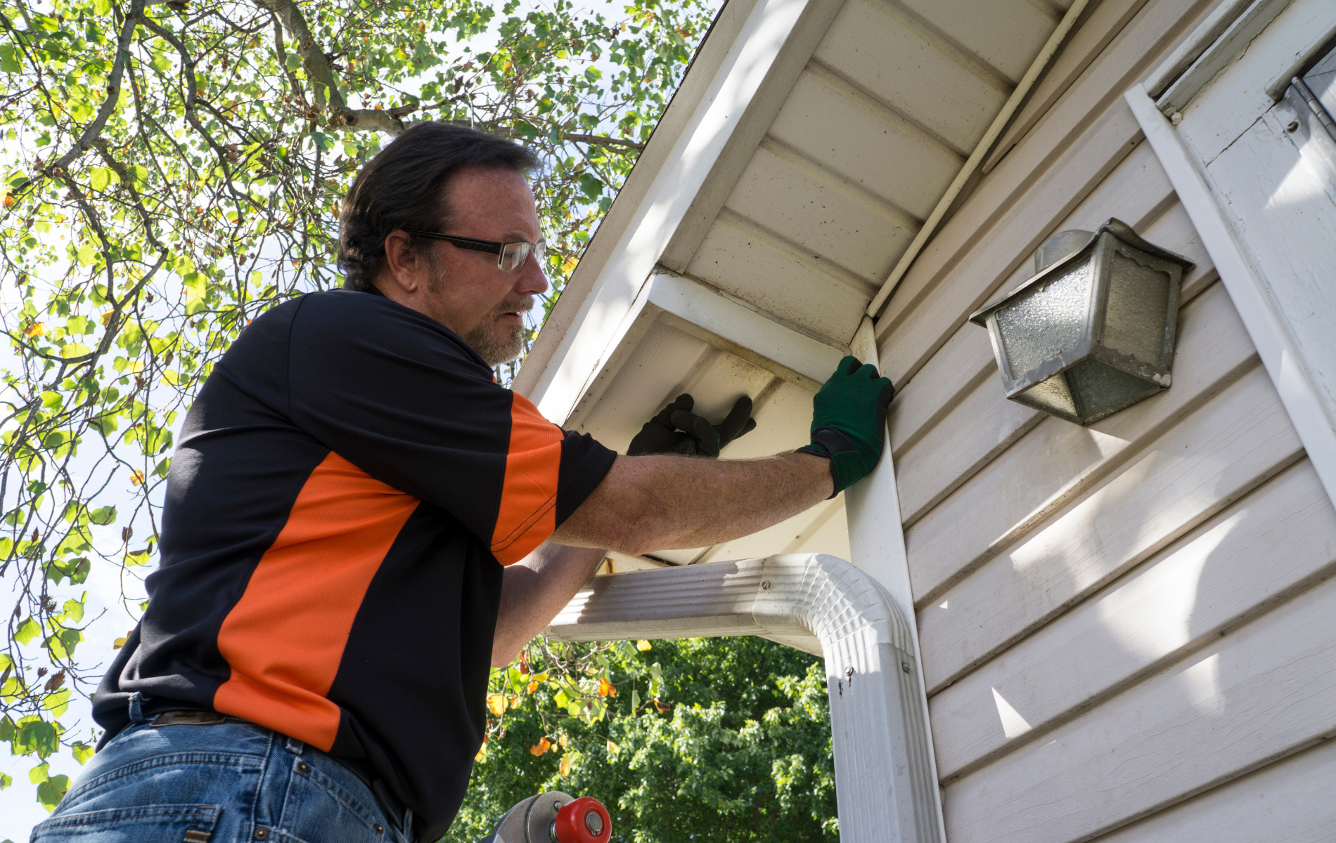 A man is working on the side of a house.