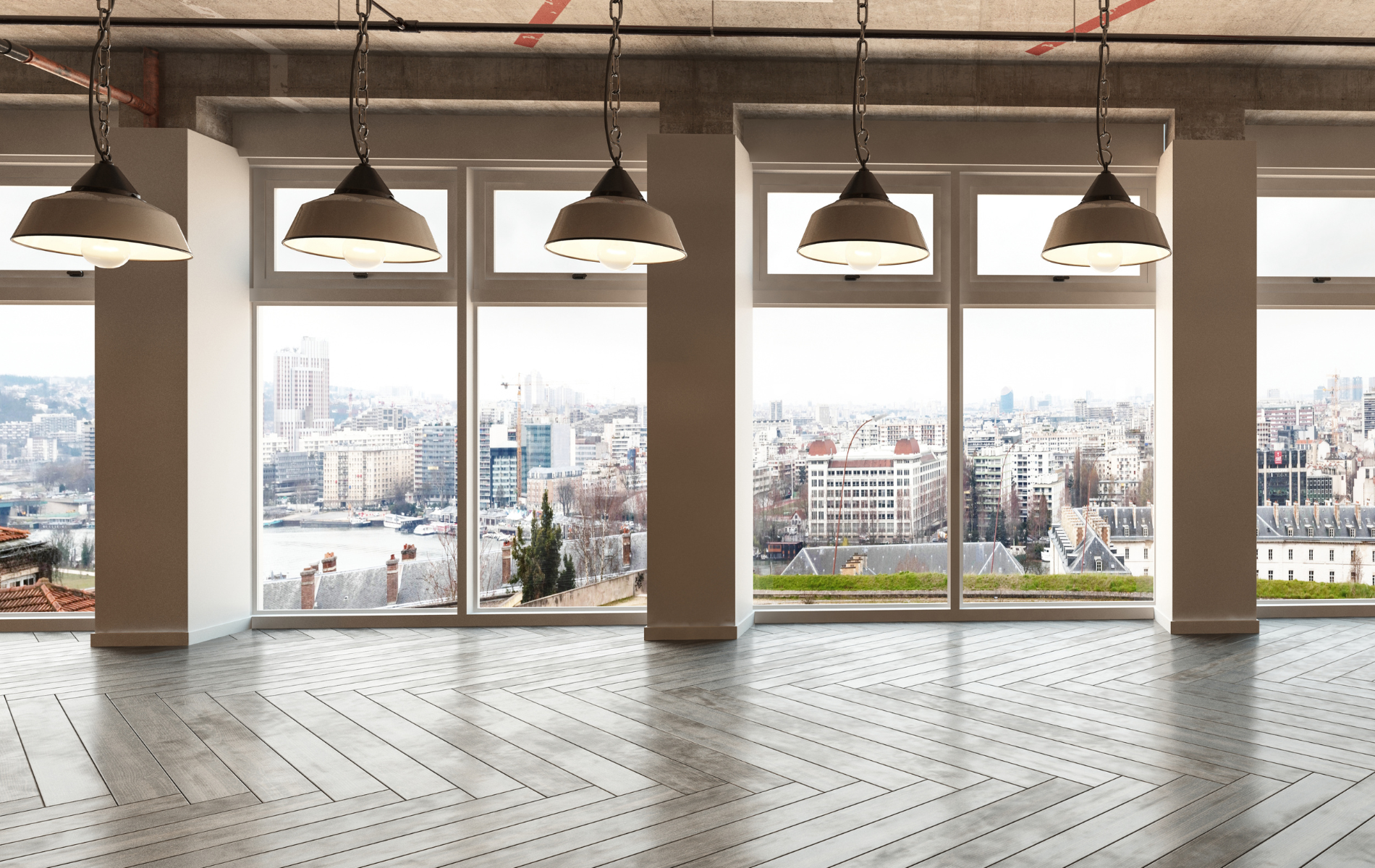 An empty room with a lot of windows and a view of the city.