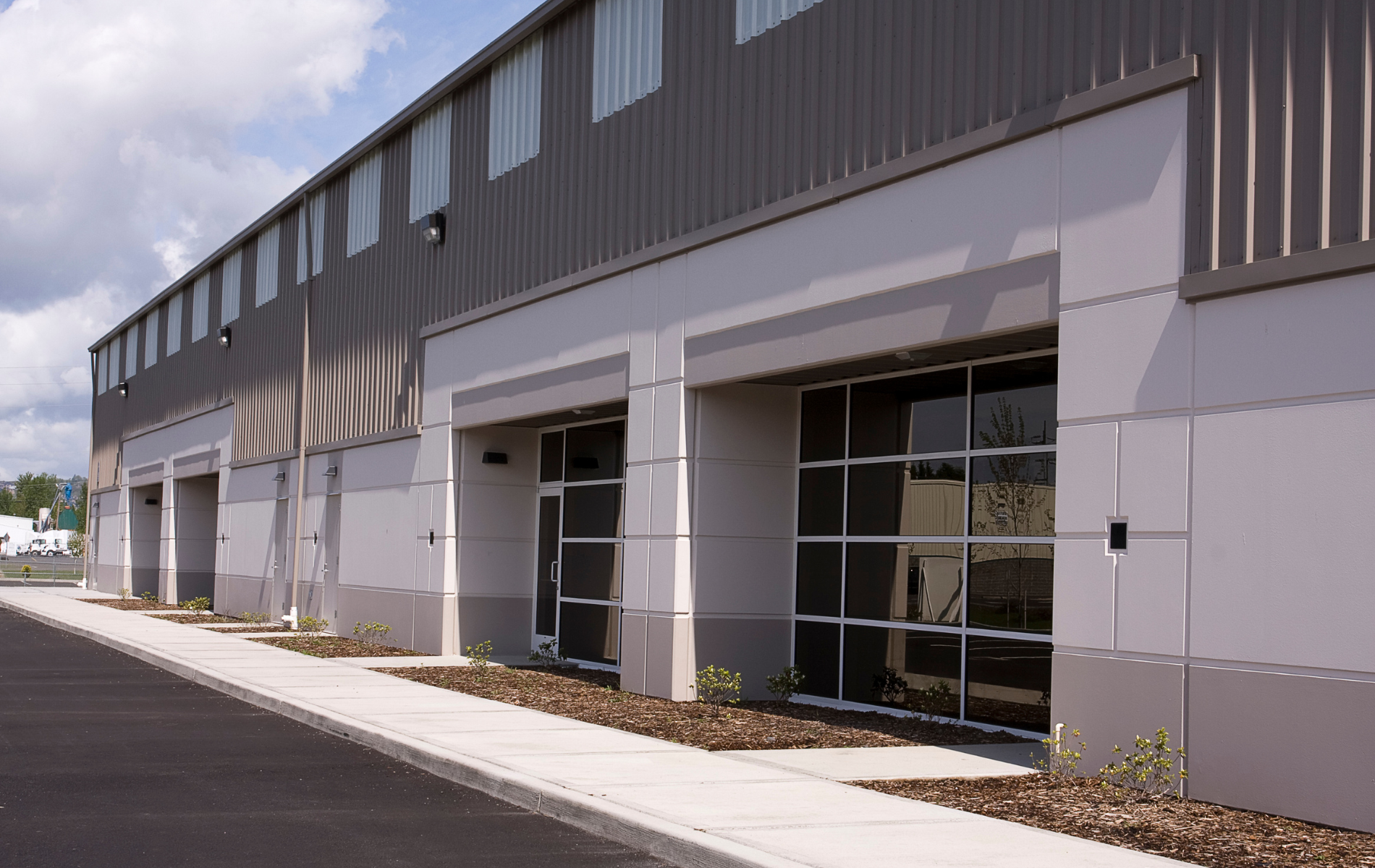 A building with a lot of windows and a sidewalk in front of it