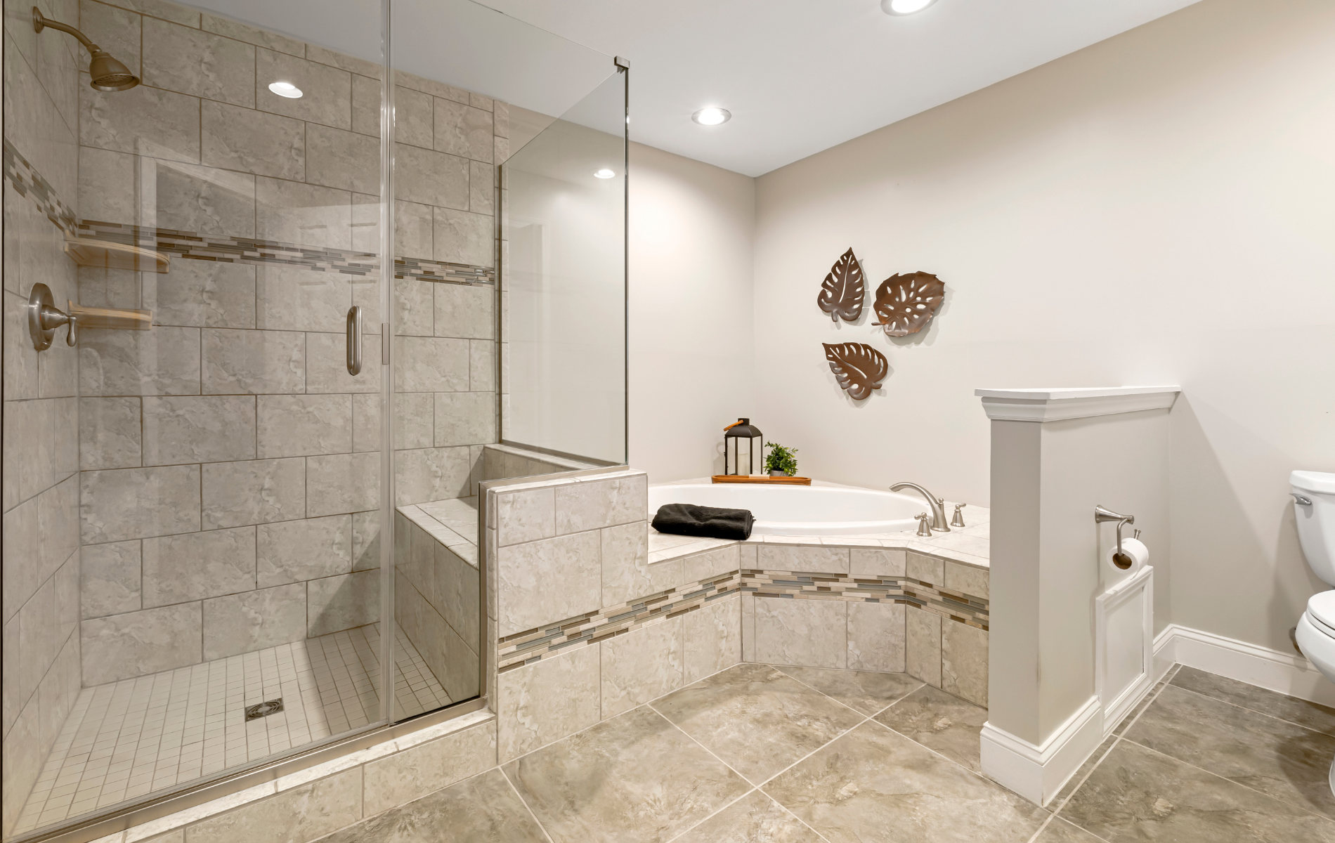 A bathroom with a walk in shower , tub and toilet.