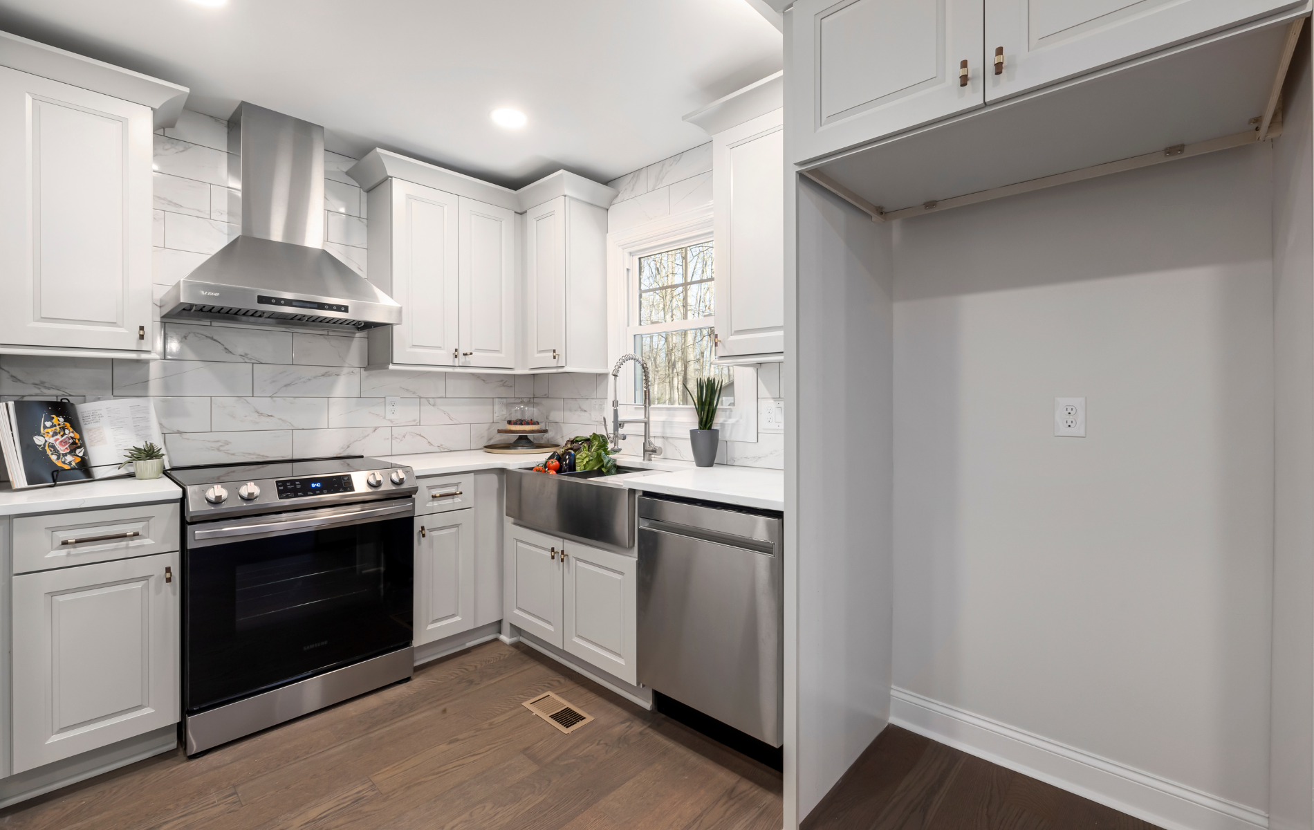 A kitchen with white cabinets and stainless steel appliances.