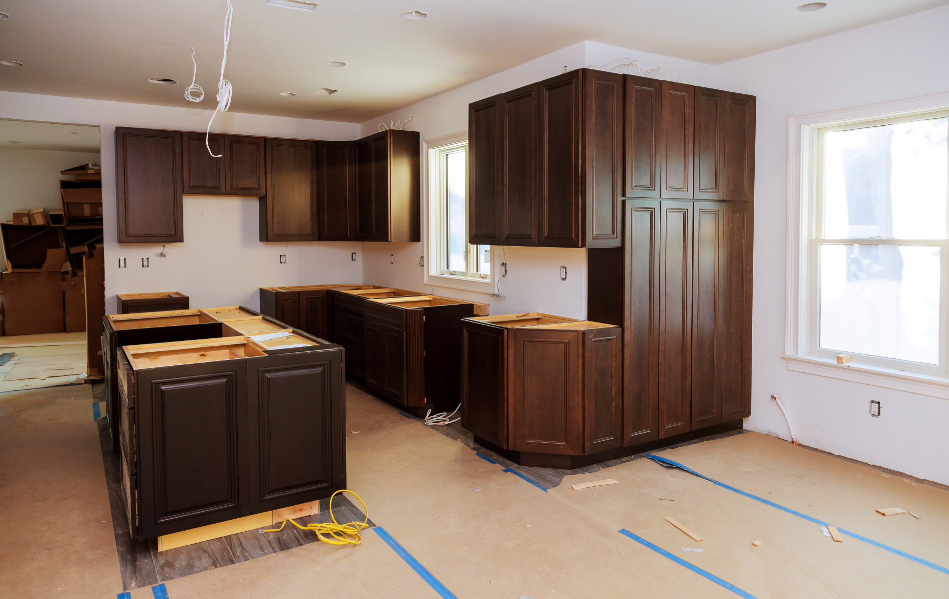 A kitchen under construction with wooden cabinets and a large island.