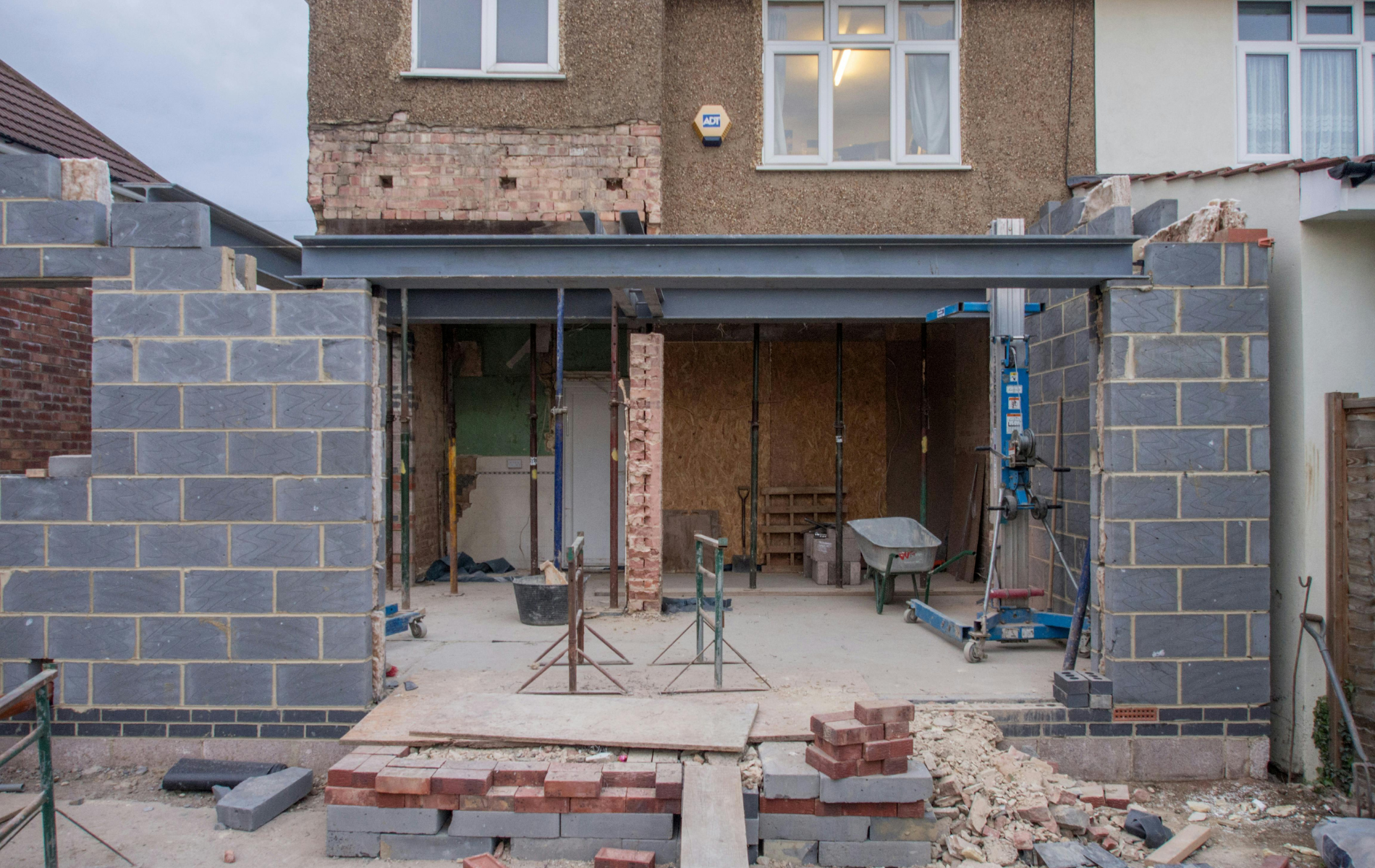 A house is being built with bricks and a metal frame.