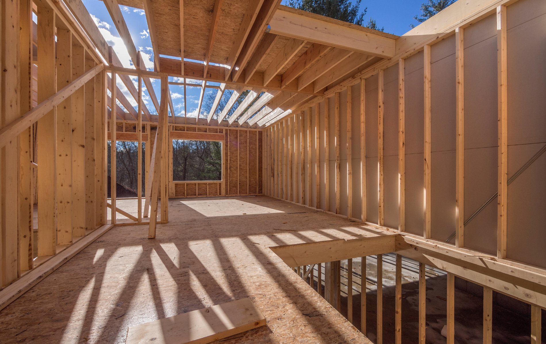 The inside of a house under construction with wooden beams.