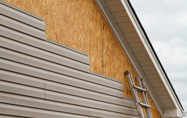 A ladder is sitting on the side of a house.